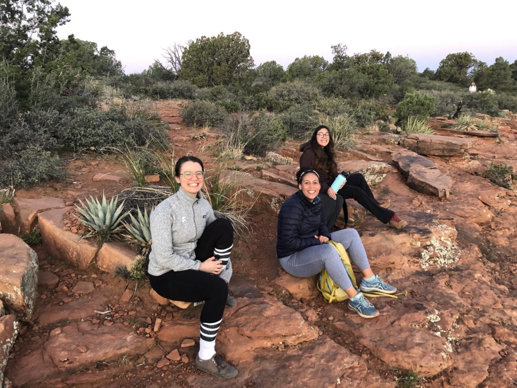 Three women sitting in the desert