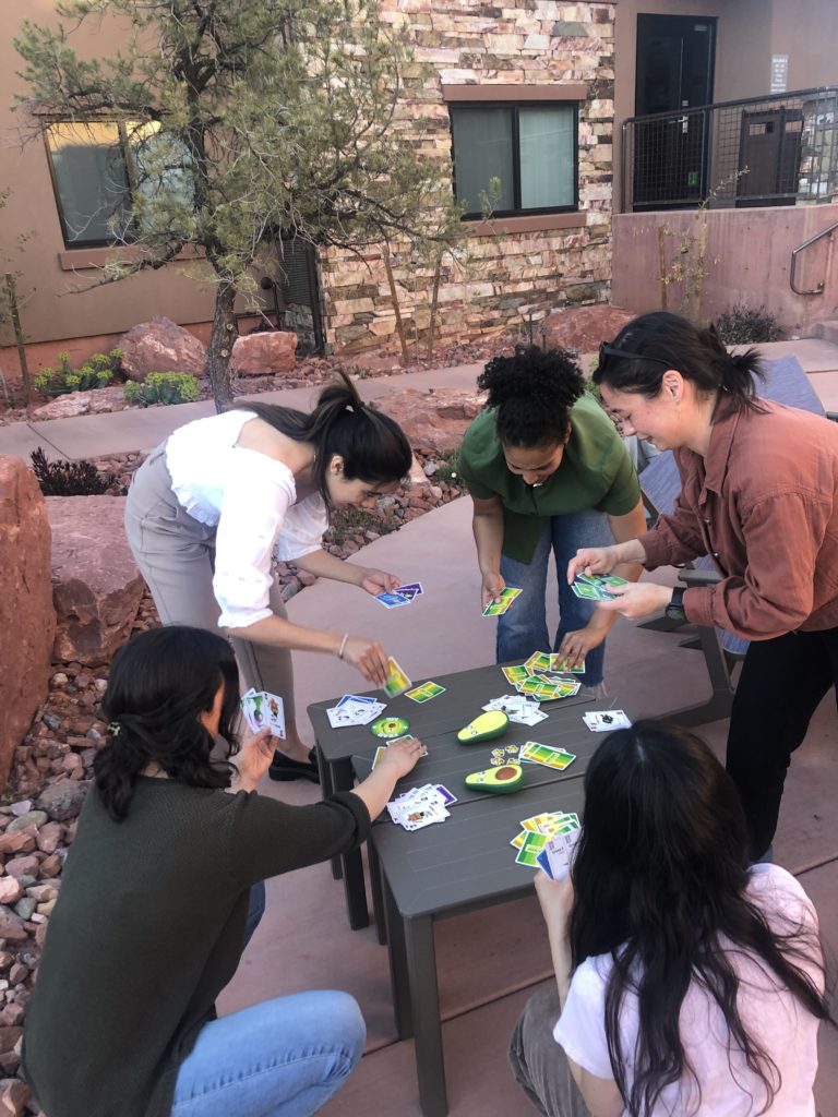 Five women playing a card game